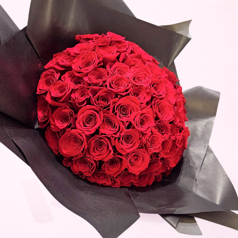 Ramo de rosas rojas premium envuelto en papel elegante tipo bouquet